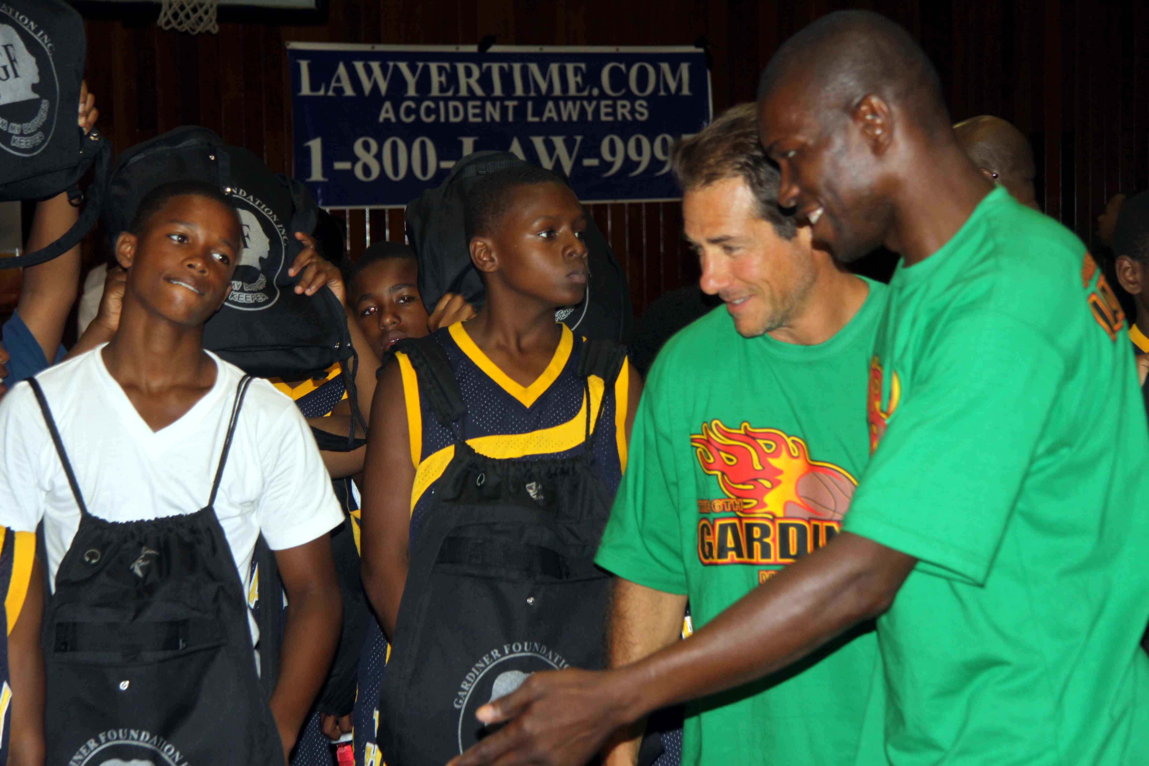 Jeff Korek and Dexter Gardiner hand out backpacks filled with school supplies